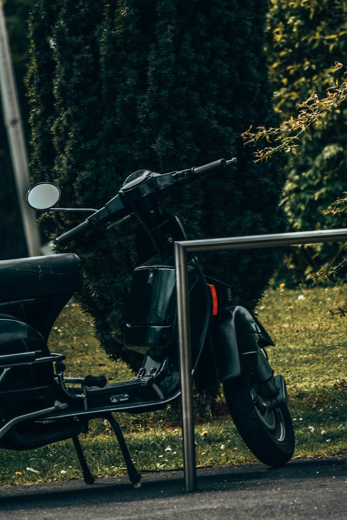 Avant d'une moto noire garée, optique et clignotants visibles